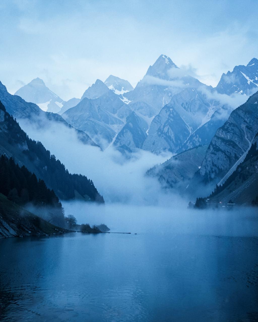 Misty mountain range above a still lake